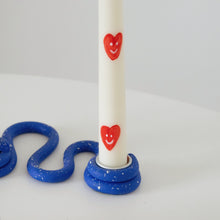 Load image into Gallery viewer, Heart smiley tapers in a blue candle holder
